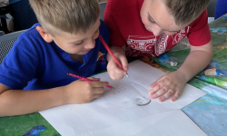 Dva učenika zajedno crtaju crtež