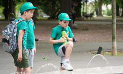 3 osnovca gledaju u fontanu