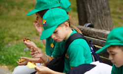 Učenice sede na klupi i jedu čokoladu