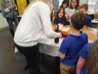 Učiteljica lomi kolač i posipa vino