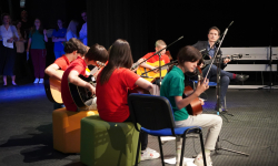 Učenici sviraju gitare sa nastavnikom Učenici sviraju gitare sa nastavnikom