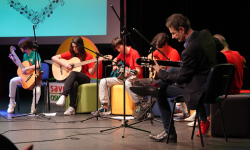 Učenici i nastavnik sviraju gitare Učenici i nastavnik sviraju gitare