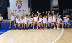 Učenici sede na terenu i mašu