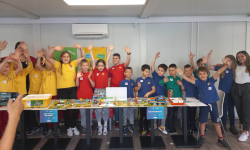 Osnovci mašu ispred grada napravljenog od LEGO kockica